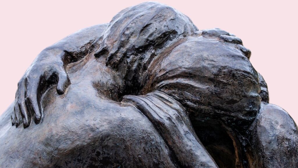 Das Bild zeigt eine Bronze-Skulptur, von zwei Menschen, die sich umarmen.